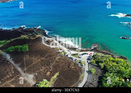Ein atemberaubender Blick aus der Luft auf Mauis Küste mit lebhaftem türkisfarbenem Wasser, schwarzem vulkanischem Felsen und üppiger grüner Vegetation. Das Bild wird erfasst Stockfoto