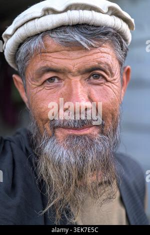 Afghane mit traditionellem Pakolhut, der vor der Kamera lächelt Stockfoto
