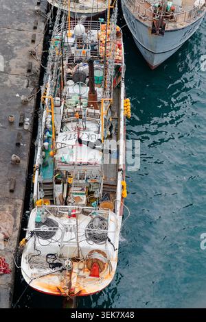 Yilan, Taiwan - 31. März 2025: Luftaufnahme eines Fischereifahrzeugs in Nanfangao mit Deck, das mit Seilen, Schwimmern und Ausrüstung neben einem grauen Schiff beladen ist. Stockfoto