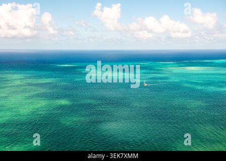 Ein Weitwinkel-Luftbild, das die Weite des tiefblauen Karibischen Meeres vor Grand Cayman und das pulsierende türkisfarbene Wasser zeigt Stockfoto