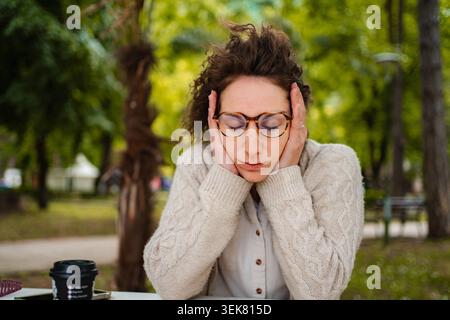 Frau, die Stress, Kopfschmerzen, Angst im Freien hat Stockfoto