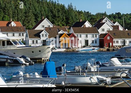 Skandinavische Bootskultur mit Freizeitbooten, Yachthäfen und farbenfrohen Häusern am Wasser in der Nähe des Leuchtturms Lindesnes in Norwegen für Sommerreisen und Stockfoto