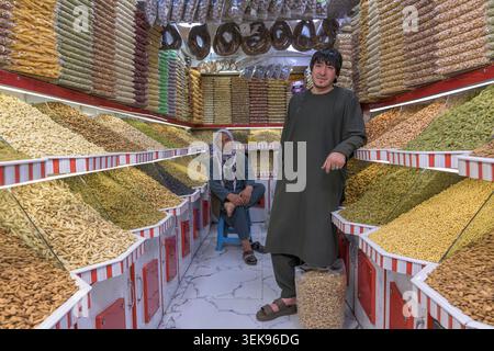 Ladenbesitzer bieten verschiedene Nüsse und getrocknete Früchte an ihrem gut sortierten Marktstand an Stockfoto