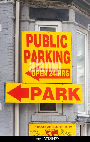 Toronto, Kanada - 26. Mai 2026: Bright Yellow Public Parking Schilder mit Wegbeschreibungen und Öffnungszeiten Stockfoto