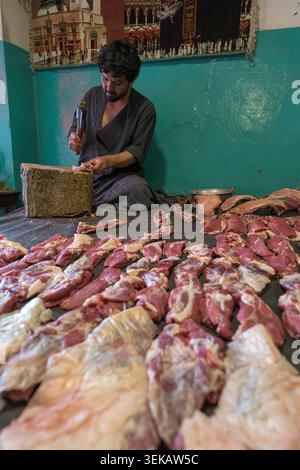 Metzger, der Rohfleischportionen für den Verkauf in einem traditionellen Marktrestaurant in Kabul zubereitet. Stockfoto