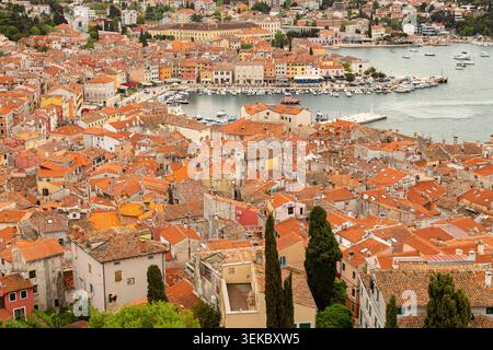 Aus der Vogelperspektive auf die Altstadt und den Hafen von Rovinj, Kroatien, mit dichten Gebäuden mit Terrakottadächern und vertäuten Booten. Stockfoto