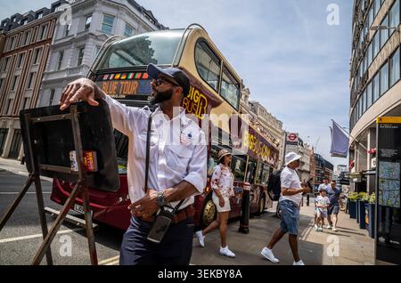 Ein Busführer steht neben einer Haltestelle der Big Bus London, Hop-on-Hop-off-Busse, während Touristen am Ludgate Hill in der City of London, England, Großbritannien, aussteigen Stockfoto
