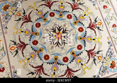 Aufwändige handgestickte Suzani-Textilien mit kreisförmigem Blumenmedaillon, farbenfrohen Motiven und verzierten sich wiederholenden Mustern auf natürlichem Stoff Stockfoto