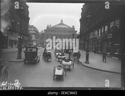 Auf einem Pressefoto sind die Pedalwagen-Wettbewerber und Fahrzeuge aufgezeichnet, die am 8. Juli 1928 auf der Avenue de l’Opéra vor dem Palais Garnier in Paris während des Tour de France Tretwagen-Wettbewerbs montiert wurden. Agence Rol dokumentierte die Veranstaltung und ihre Teilnehmer. Stockfoto