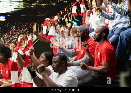 Viele Fußballfans sehen sich Live-Fußballspiele im Stadion an, die voller jubelnder Fans sind. Sportfans mit Gesangsgesang für die rote Mannschaft, Spieltagatmosphäre. Stockfoto