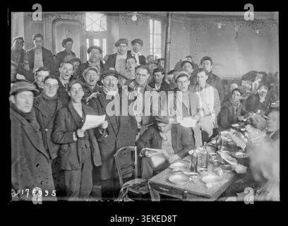 Ein Pressefoto zeigt arbeitslose Teilnehmer des hungermarsches aus Nordfrankreich am 30. November 1933 in Nogent-sur-Oise. Die Gruppe singt zusammen während eines Essens, während Demonstranten sich in einem kollektiven Porträt versammeln, das mit den Protesten der Arbeitslosigkeit in Verbindung steht. Stockfoto
