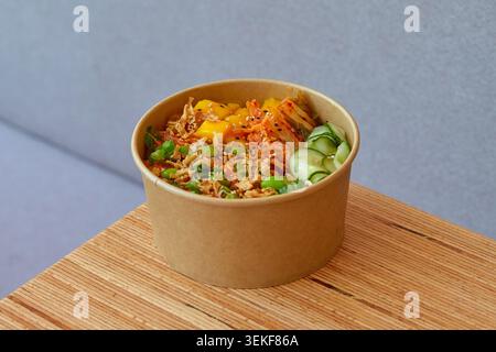 Lachspoke in scharfer Sauce, Mango, Kimchi, Gurkenpickle, Edamame, Frühlingszwiebeln, knusprige gebratene Zwiebeln, Sesamsamen, Reisbasis Stockfoto