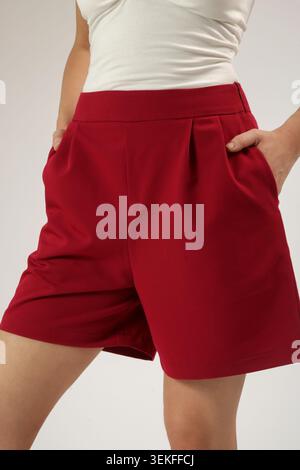 Nahaufnahme des Fashion Models mit roten maßgeschneiderten Shorts mit Pokets – stylische Sommergarderobe, elegantes Casual und modernes Modekonzept Stockfoto