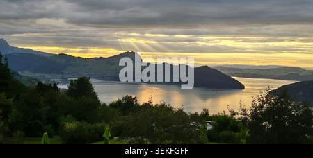 Dramatische Sonnenstrahlen, Die Durch Die Sturmwolken Über Dem Vierwaldstättersee Bei Emmetten In Der Schweiz Brechen Und Die Berge Und Das Wasser Darunter Beleuchten Stockfoto
