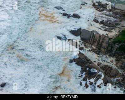 Surfen Sie über Granitfelsen an der Atlantikküste von Kapstadt Stockfoto