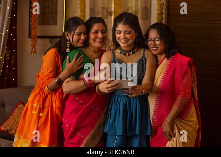 Porträt einer Familie mit drei Generationen, die zu Hause auf Diwali Spaß macht Stockfoto