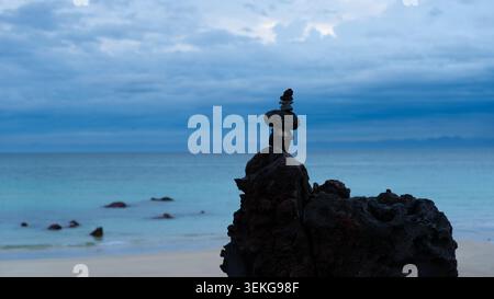 Ausgeglichener Steinkairn auf vulkanischem Basaltgestein zur blauen Stunde, Aewol Beach, Jeju Island, Südkorea Stockfoto