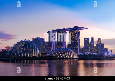 Marina Bay Sands Hotel and Gardens by the Bay Supertrees beleuchtet in der Abenddämmerung, Skyline von Singapur spiegelt sich in Marina Bay, Südostasien Stockfoto