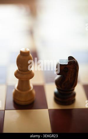Hölzerner Schachbischof und Ritter auf Schachbrett, geringe Tiefe des Feldes, Strategie und Entscheidungskonzept Stockfoto