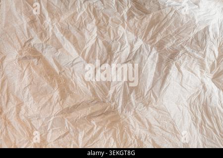 Detaillierte, zerknitterte braune Papierstruktur mit unregelmäßigen Falten und Schatten Stockfoto