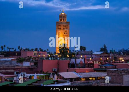 Nachtblick über Dächer zum beleuchteten Minarett der Koutoubia Moschee in der Medina von Marrakesch in Marokko, Nordafrika Stockfoto