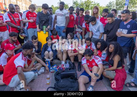 Arsenal-Fans treffen sich vor dem Drayton Park Arms Pub in der Nähe des Emirates Stadium, um das Champions League-Finale gegen PSG auf einem Laptop zu sehen. Stockfoto