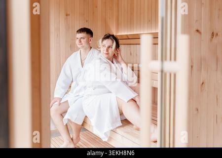 Das Junge Weiße Paar Ruht Während Des Wellness-Wochenendes In Der Holzsauna Aus Stockfoto