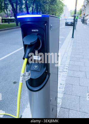 Nahaufnahme einer Ensto-Ladestation für Elektrofahrzeuge mit einem gelben Kabel, das auf einem Bürgersteig in oslo norwegen angeschlossen ist Stockfoto