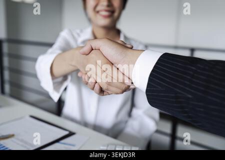 Zwei verschiedene professionelle Führungskräfte schütteln sich nach dem Treffen im Büro die Hand Stockfoto