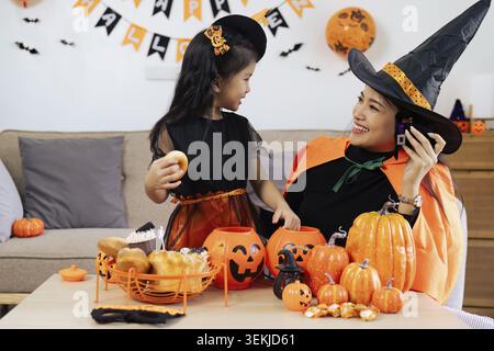 Mutter und Tochter haben zu Hause Spaß. Glückliche Familie bereitet sich auf Halloween vor Stockfoto