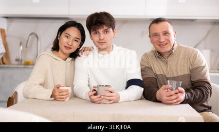 Erwachsener Mann und sitzt am Tisch in der Küche Stockfoto