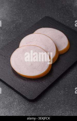 Hühnchen oder indische Wurst oder Schinken in Scheiben für Frühstückssandwiches. Hähnchenwurstscheiben als Lebensmittelhintergrund für Ihr Design Stockfoto