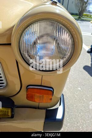 WORONESCH, Russland - 25. April 2026. Nahansicht zeigt einen runden Glasscheinwerfer und einen orangefarbenen Blinker bei einem beigefarbenen Trabant-Oldtimer. Heller Sonnenschein Stockfoto