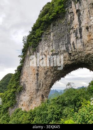 Natürlicher Kalksteinbogen über dem tropischen Wald in Ha Long Bay, Vietnam Stockfoto