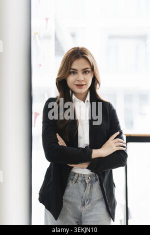Porträt einer jungen, glücklichen Frau und selbstbewusster Arbeit im Büro Stockfoto