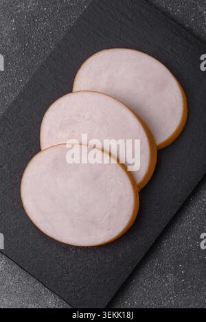 Hühnchen oder indische Wurst oder Schinken in Scheiben für Frühstückssandwiches. Hähnchenwurstscheiben als Lebensmittelhintergrund für Ihr Design Stockfoto