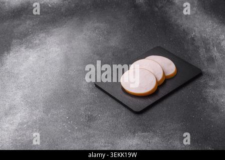 Hühnchen oder indische Wurst oder Schinken in Scheiben für Frühstückssandwiches. Hähnchenwurstscheiben als Lebensmittelhintergrund für Ihr Design Stockfoto