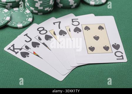 Karten und Chips auf einem grünen Tuch spielen, ein Poker-Spiel. Karten und Chips auf einem Spieltisch als Hintergrund für Ihr Design Stockfoto