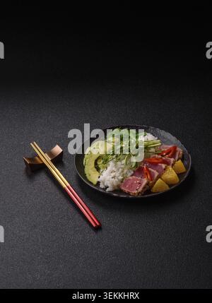 Gebratene Thunfisch-Tataki in einer Schüssel mit Sesamsamen, Reis und Gemüse. Thunfisch Tataki als Hintergrund für Ihr Design Stockfoto