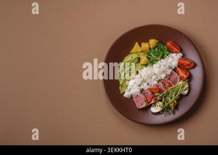 Gebratene Thunfisch-Tataki in einer Schüssel mit Sesamsamen, Reis und Gemüse. Thunfisch Tataki als Hintergrund für Ihr Design Stockfoto