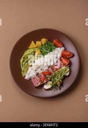 Gebratene Thunfisch-Tataki in einer Schüssel mit Sesamsamen, Reis und Gemüse. Thunfisch Tataki als Hintergrund für Ihr Design Stockfoto
