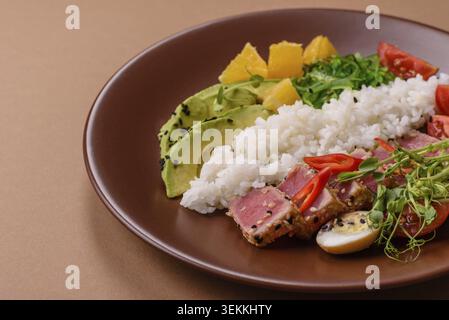 Gebratene Thunfisch-Tataki in einer Schüssel mit Sesamsamen, Reis und Gemüse. Thunfisch Tataki als Hintergrund für Ihr Design Stockfoto