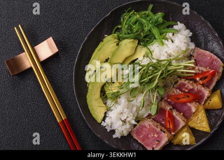 Gebratene Thunfisch-Tataki in einer Schüssel mit Sesamsamen, Reis und Gemüse. Thunfisch Tataki als Hintergrund für Ihr Design Stockfoto