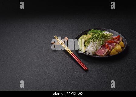 Gebratene Thunfisch-Tataki in einer Schüssel mit Sesamsamen, Reis und Gemüse. Thunfisch Tataki als Hintergrund für Ihr Design Stockfoto