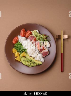 Gebratene Thunfisch-Tataki in einer Schüssel mit Sesamsamen, Reis und Gemüse. Thunfisch Tataki als Hintergrund für Ihr Design Stockfoto