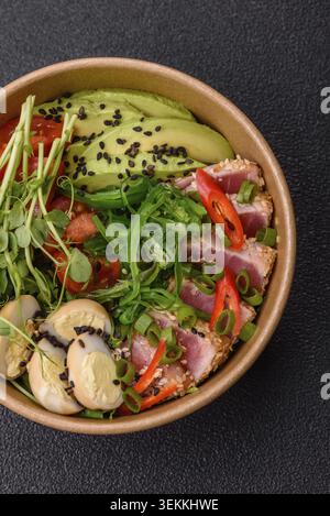 Gebratene Thunfisch-Tataki in einer Schüssel mit Sesamsamen, Reis und Gemüse. Thunfisch Tataki als Hintergrund für Ihr Design Stockfoto
