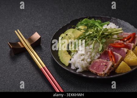 Gebratene Thunfisch-Tataki in einer Schüssel mit Sesamsamen, Reis und Gemüse. Thunfisch Tataki als Hintergrund für Ihr Design Stockfoto