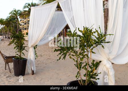 Blick auf einen Bogen mit weißen Vorhängen am Strand Stockfoto