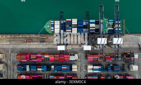 Luftaufnahme eines Containerschiffs, das von Kränen an einem internationalen Schiffsterminal bedient wird, das den globalen Handel und die Logistik in thailand repräsentiert. Stockfoto