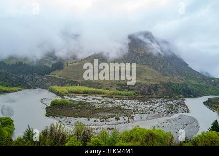 Hochwinkelblick auf das gewundene Bett des Shotover River Canyon unter einer schweren Decke aus niedrig hängendem alpinen Nebel, Nebel und niedrigen Wolken. Stockfoto